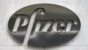 Pfizer logo on metal placard with marble backdrop. Stocks to Double