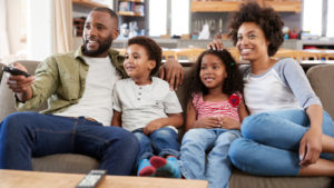 a picture of a family sitting on a couch. entertainment stocks